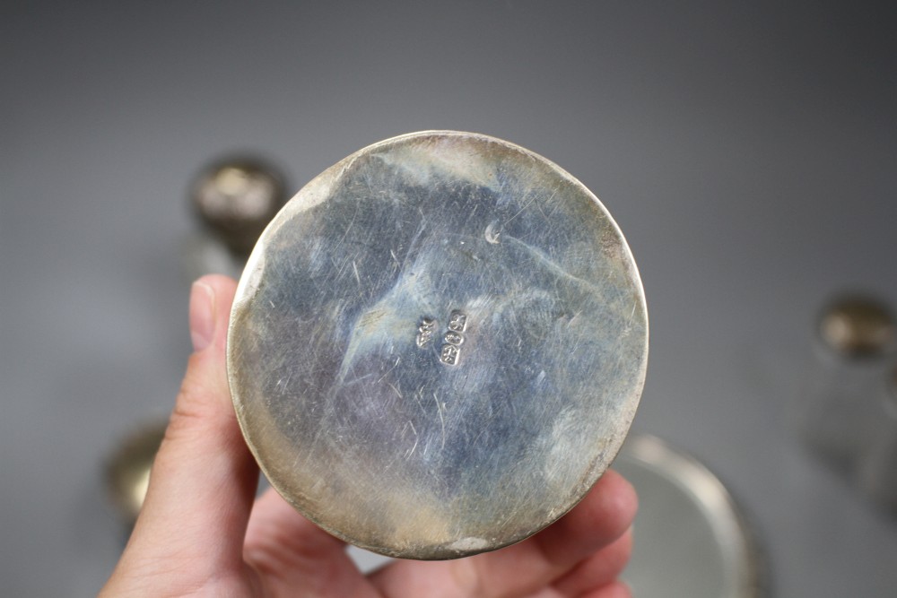 A late Victorian silver circular box and cover, a pair of similar silver mounted glass scent bottles, etc